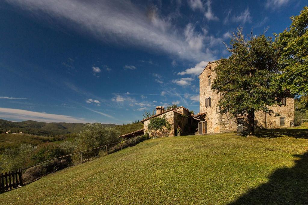 an old stone building on a grassy field at Casavecchia 12 by Salogi Villas in Volpaia