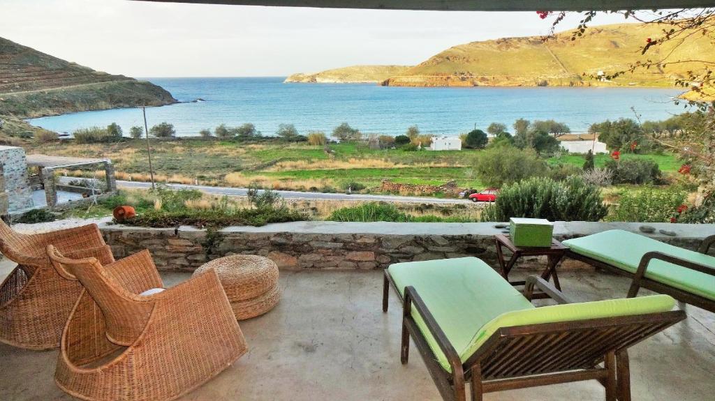 a patio with chairs and a view of the water at Serifos Dream Houses near the sea in Ganema