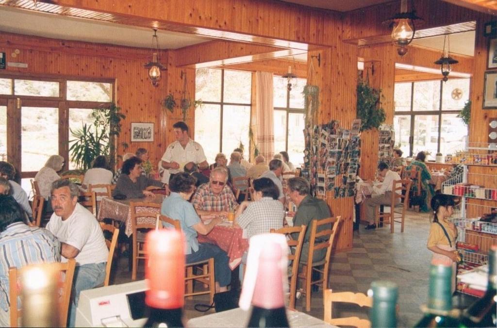 un gruppo di persone seduti ai tavoli in un ristorante di Neos Omalos Hotel a Omalos