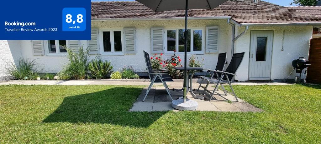 a table and chairs under an umbrella in front of a house at FN City Bungalow in Friedrichshafen