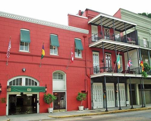 un bâtiment rouge avec des drapeaux devant lui dans l'établissement Plaza Suites Downtown New Orleans, à La Nouvelle-Orléans