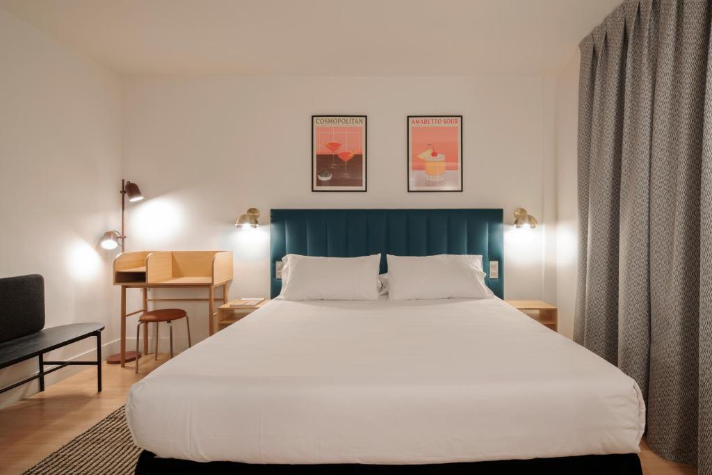 1 dormitorio con 1 cama blanca grande y escritorio en H La Paloma Adults Only, en Barcelona