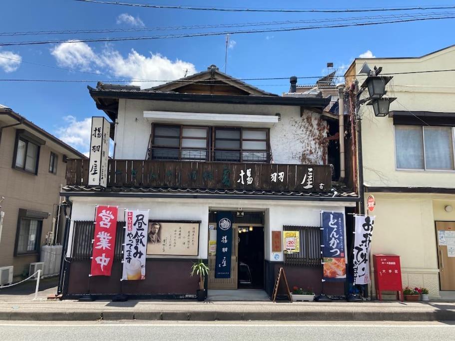 a building with asian signs on the front of it at 揚羽屋 小諸駅徒歩2分 1日1組限定 ひとりでも泊まれます Agehaya Historical house Center of the town 2minutes walk from Komoro station in Komoro