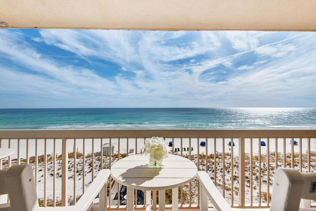 d'une table et de chaises sur un balcon donnant sur la plage. dans l'établissement Pelican Beach Resort 501, à Destin