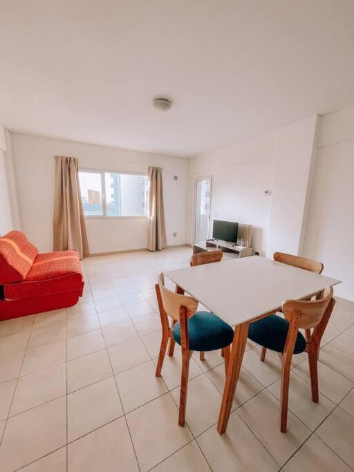 un salon avec une table et des chaises blanches dans l'établissement Espectacular departamento a metros del mar, à Puerto Madryn