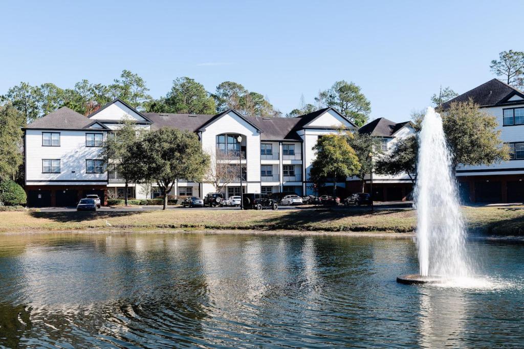 a fountain in the middle of a pond with houses at Kasa Southside Jacksonville in Jacksonville