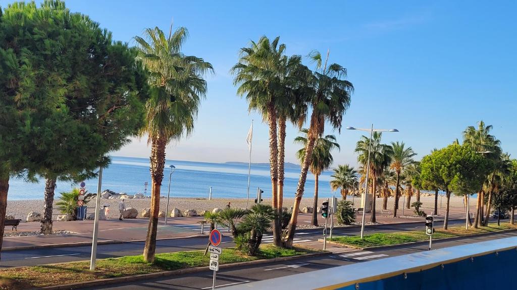 an empty street with palm trees and the beach at GRAND LARGE Méditerranée in Cagnes-sur-Mer
