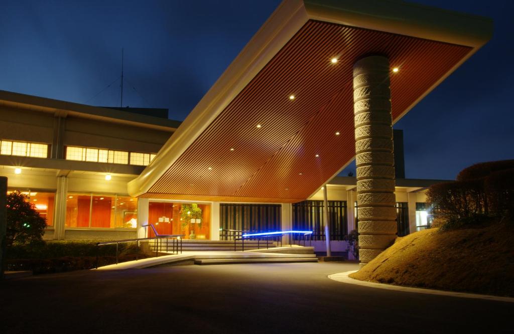 um edifício iluminado à noite com um poste em Senomoto Kogen Hotel em Minamioguni