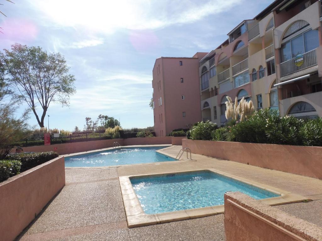 Bazén v ubytovaní AMOUREVA Joli T3 vue mer piscine Cap d Agde alebo v jeho blízkosti