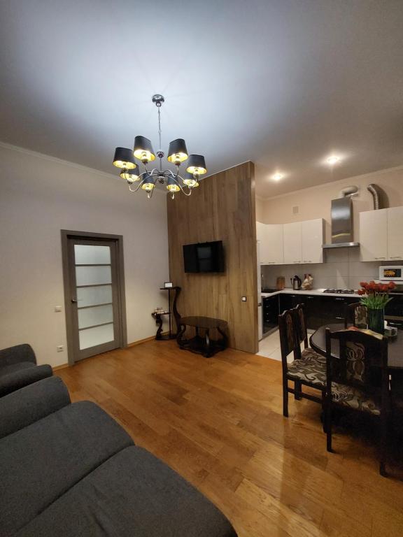 a living room with a couch and a table and a kitchen at Шикарні апартаменти поруч з Майданом in Kyiv