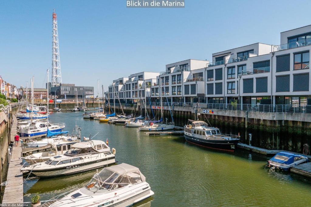 a group of boats docked in a river with buildings at Marina 22C in Cuxhaven