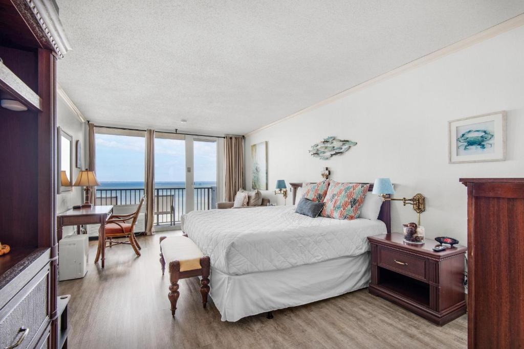 a bedroom with a bed and a desk and a balcony at Bayside Inn 6682 in Destin