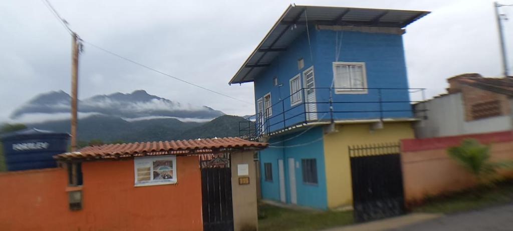 a colorful house with mountains in the background at Espaço Alto da Colina em Penedo RJ in Itatiaia