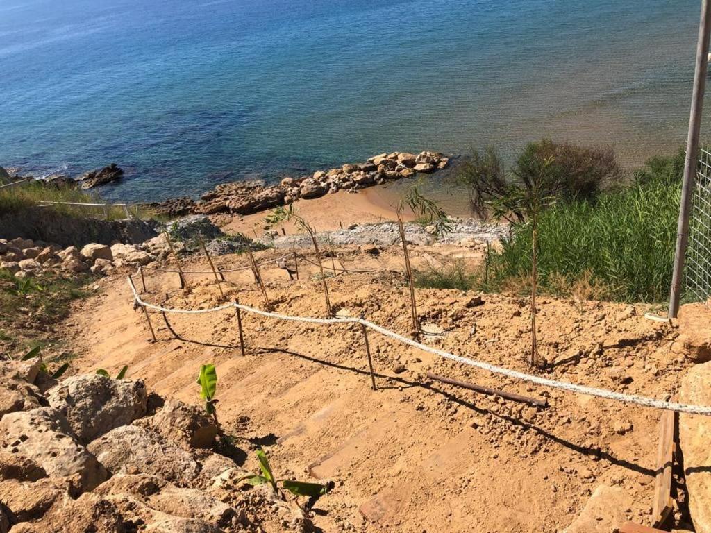 uma rede no lado de uma praia com o oceano em Casa vacanze Capo Rizzuto 1 em Ovile la Marinella