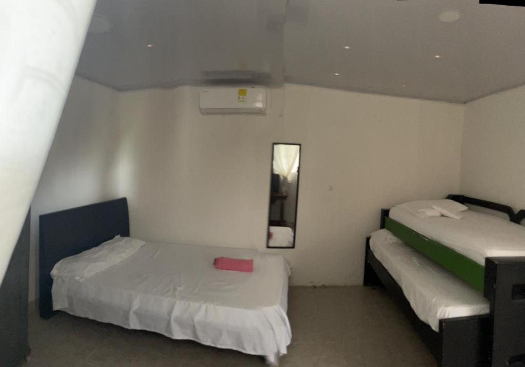 Cette chambre comprend 2 lits et un miroir. dans l'établissement sophia house, à Carthagène des Indes