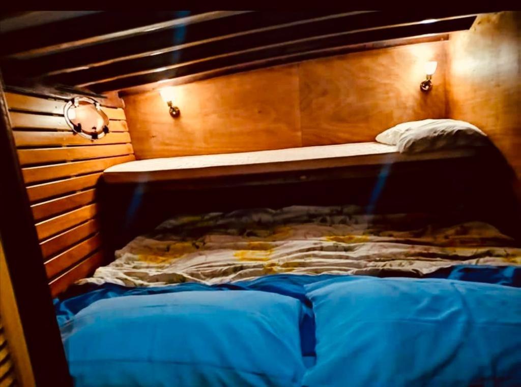 a bed in a room with a wooden head board at Motobarca Oceania in La Spezia