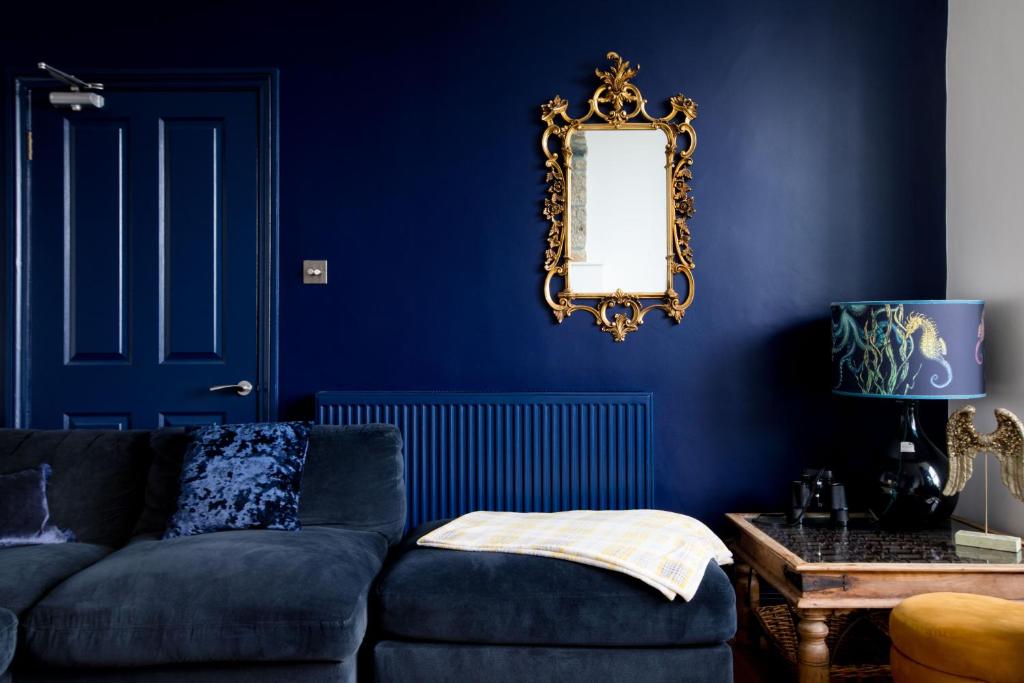 a blue living room with a couch and a mirror at Orla-Mo Victorian Captains House,St Ives,Cornwall,Sleeps10-15,Parking4cars,Refurb2022 in St Ives