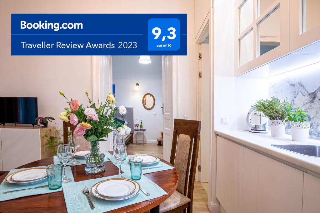 einen Tisch mit Tellern und Blumen in der Küche in der Unterkunft Apartament Ex Libris in Krakau