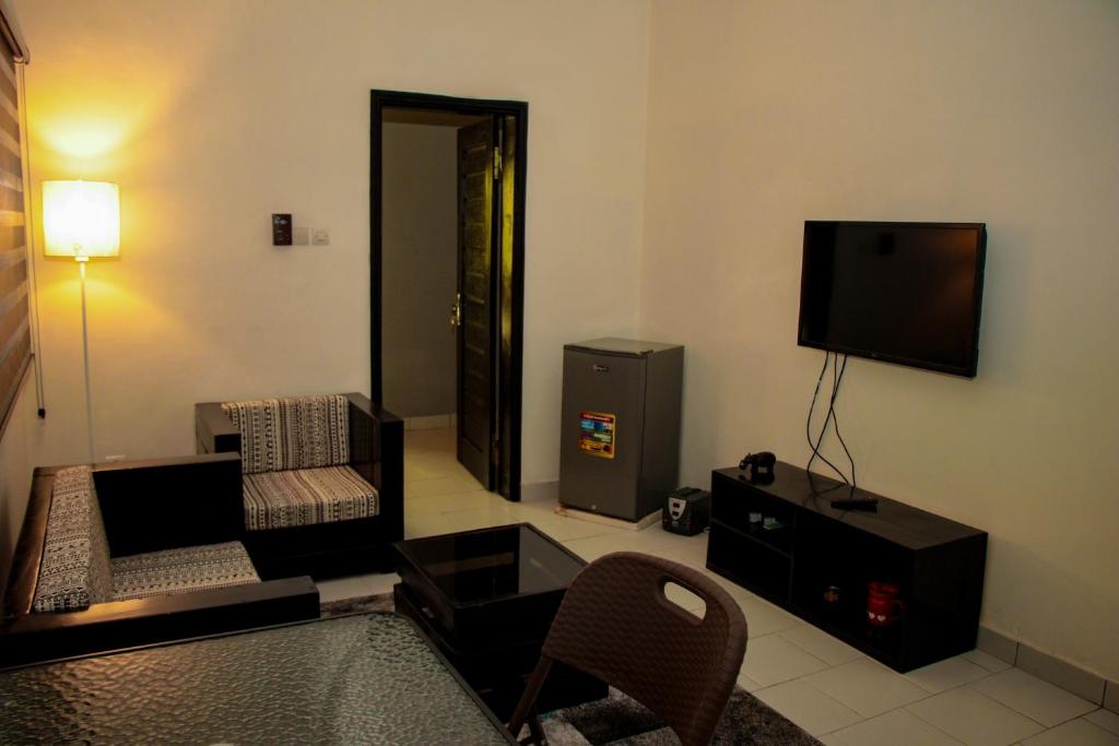 ein Wohnzimmer mit einem Sofa und einem Flachbild-TV in der Unterkunft RESIDENCES AMADIRA in Parakou
