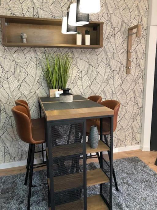 a table and chairs in a room with a wall at Luma Exclusive in Osijek