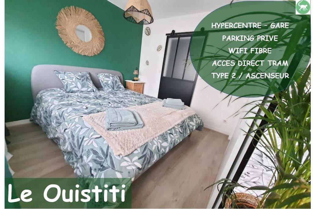 1 dormitorio con cama y pared verde en Le Ouistiti - 50 m de la Gare - Parking Privé, en Tours