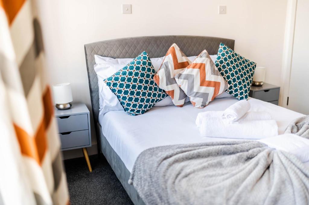 een slaapkamer met een bed met kussens erop bij Urban Oasis l 3-Bed Gem in Watford Town Center in Watford