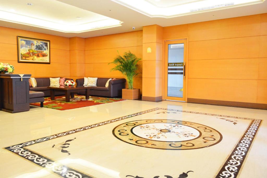 a living room with a clock on the floor at Fuward Hotel Tainan in Tainan