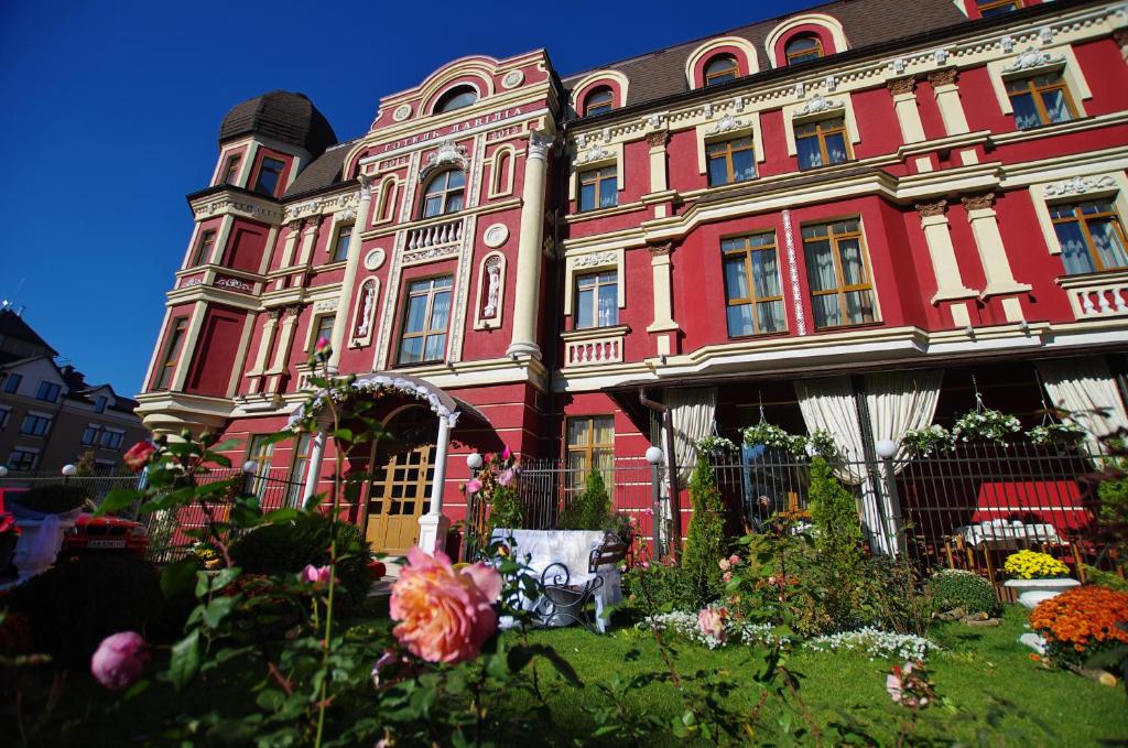 a large red building with flowers in front of it at Hotel Lavilia in Kyiv