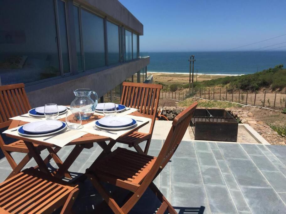 einen Tisch und Stühle auf einer Terrasse mit Meerblick in der Unterkunft Modern apartment with the best view. in Punta del Este