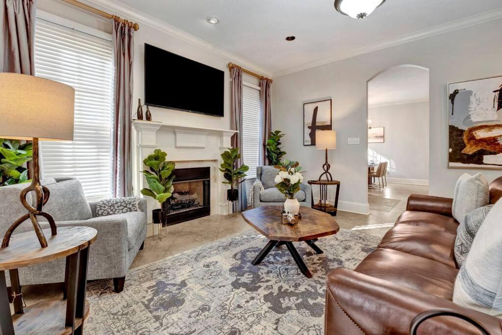 ein Wohnzimmer mit einem Sofa und einem Kamin in der Unterkunft Luxury home with outdoor patio and game room in Memphis