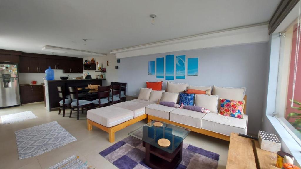 sala de estar con sofá blanco y cocina en Tu confort en Los Andes, en Baños