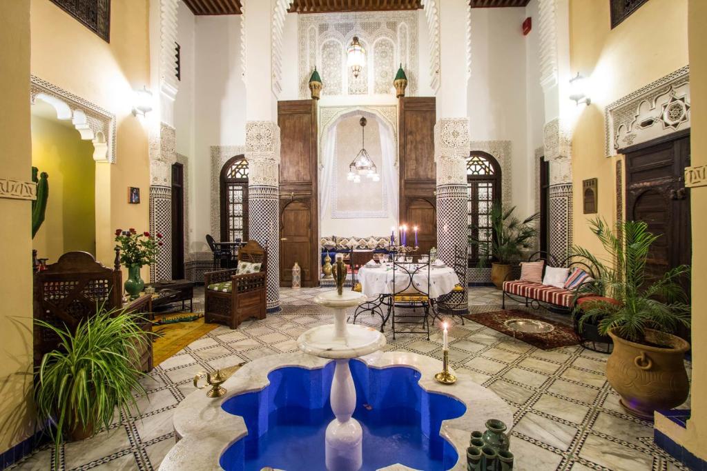 una sala de estar con una gran habitación con una mesa en Riad Letchina, en Fez