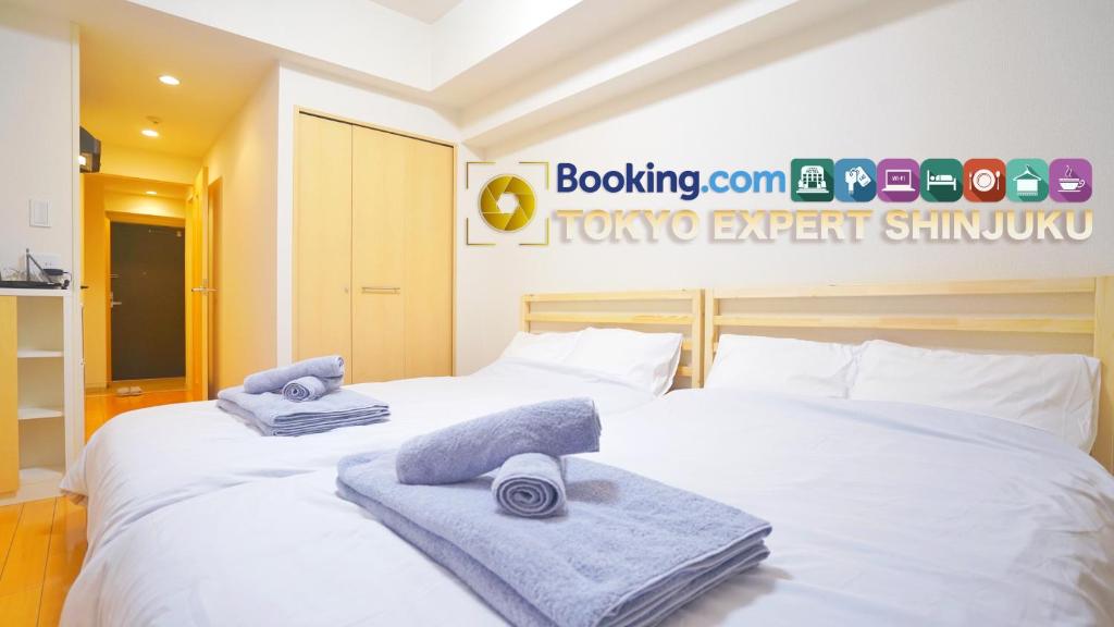 twee bedden in een hotelkamer met handdoeken erop bij TOKYO EXPERT SHINJUKU in Tokyo