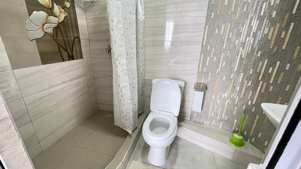 La petite salle de bains est pourvue d'une douche et de toilettes. dans l'établissement Sun & Shine Holiday Resort, à Flic-en-Flac