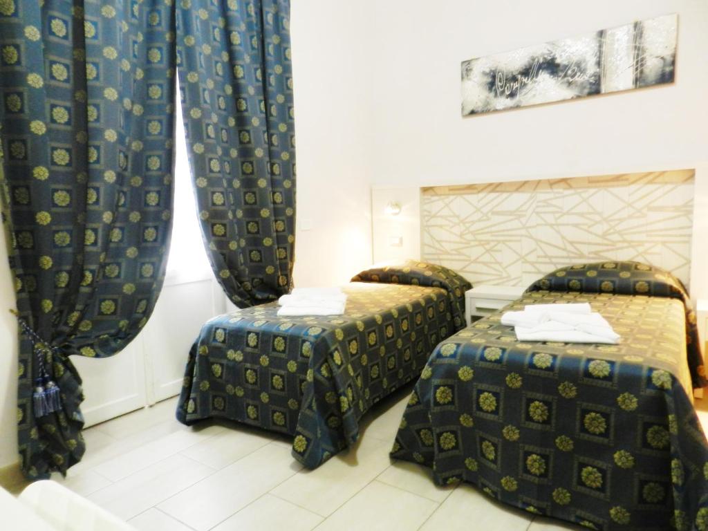 ローマにあるVatican Romeのベッド2台とカーテンが備わるホテルルームです。
