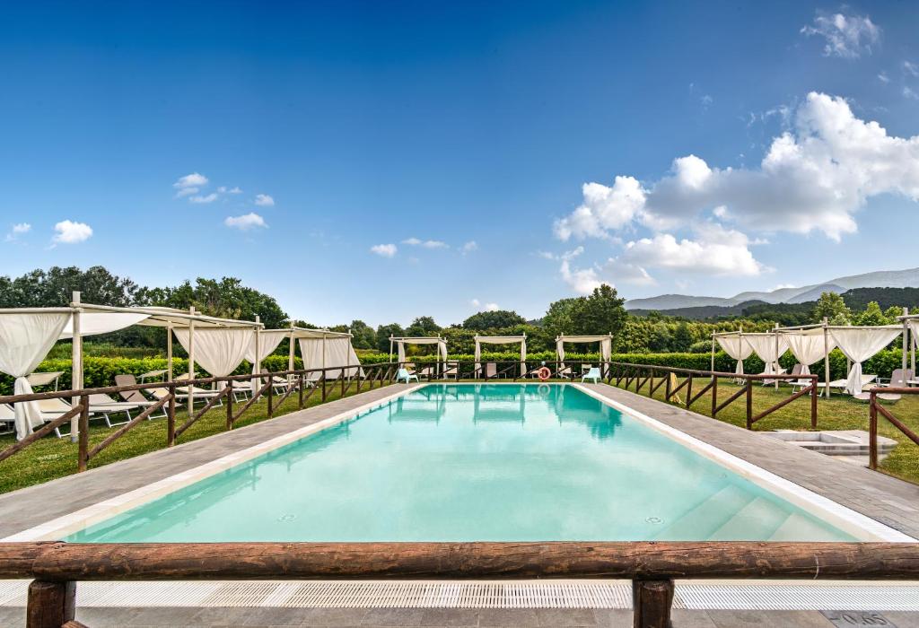 uma piscina com espreguiçadeiras e mesas em Tenuta San Giovanni Lucca em Lucca