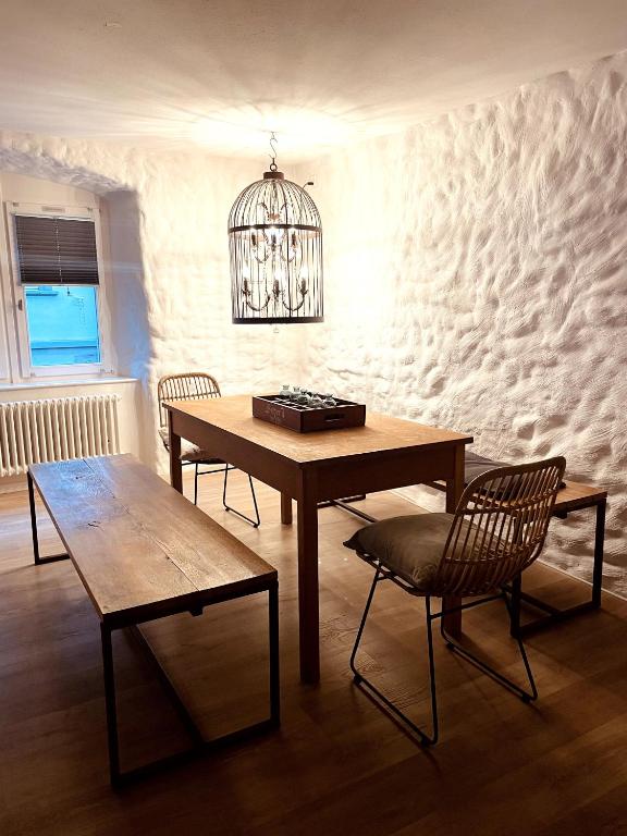 a dining room with a table and chairs and a chandelier at AIR BNBAR N°13 in Schaffhausen