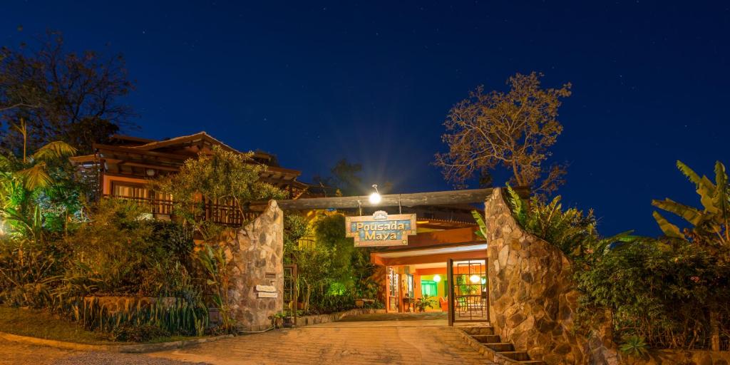 a building with a sign in front of it at night at Pousada Maya in Alto Paraíso de Goiás