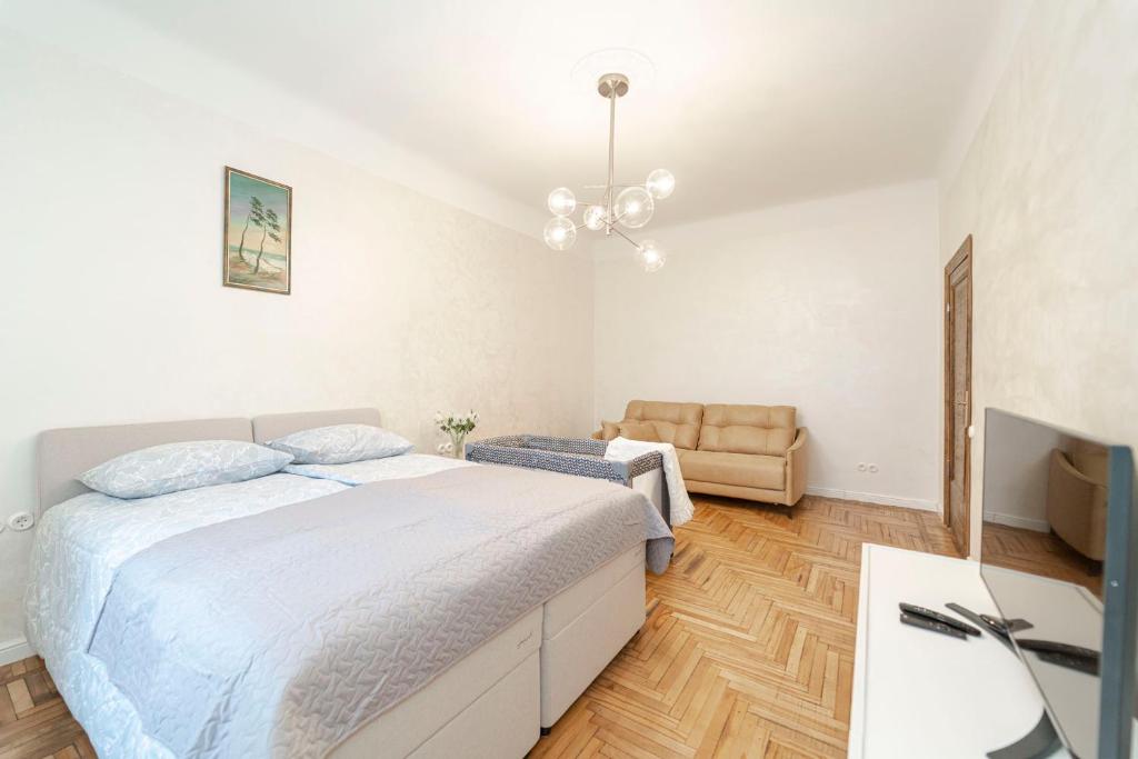 a white bedroom with a bed and a television at G11 Old Riga in Rīga