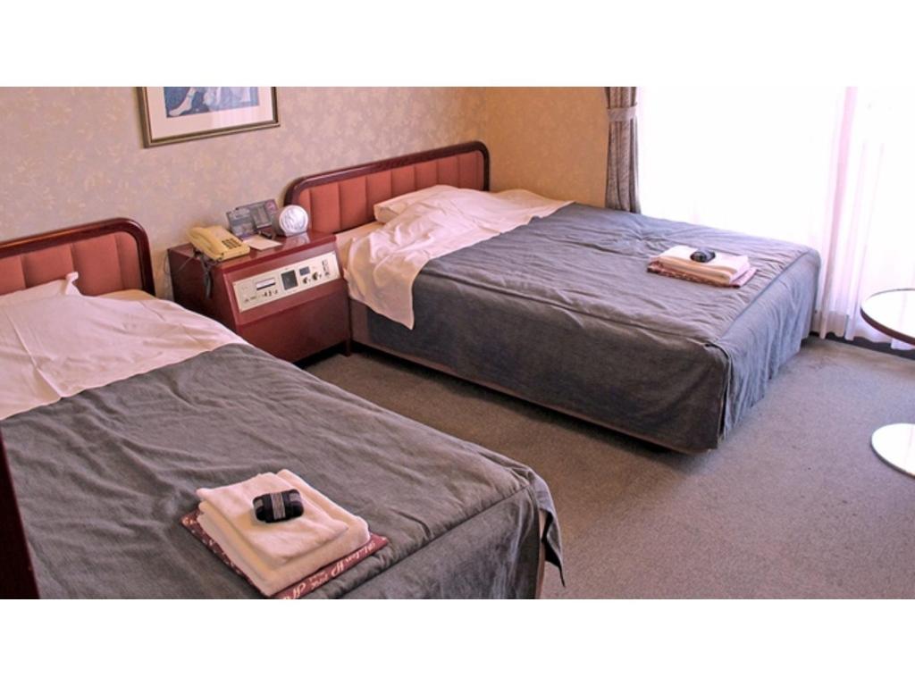 Dos camas en un dormitorio con dos bolsas. en Hotel Platon - Vacation STAY 62212v, en Chikuma