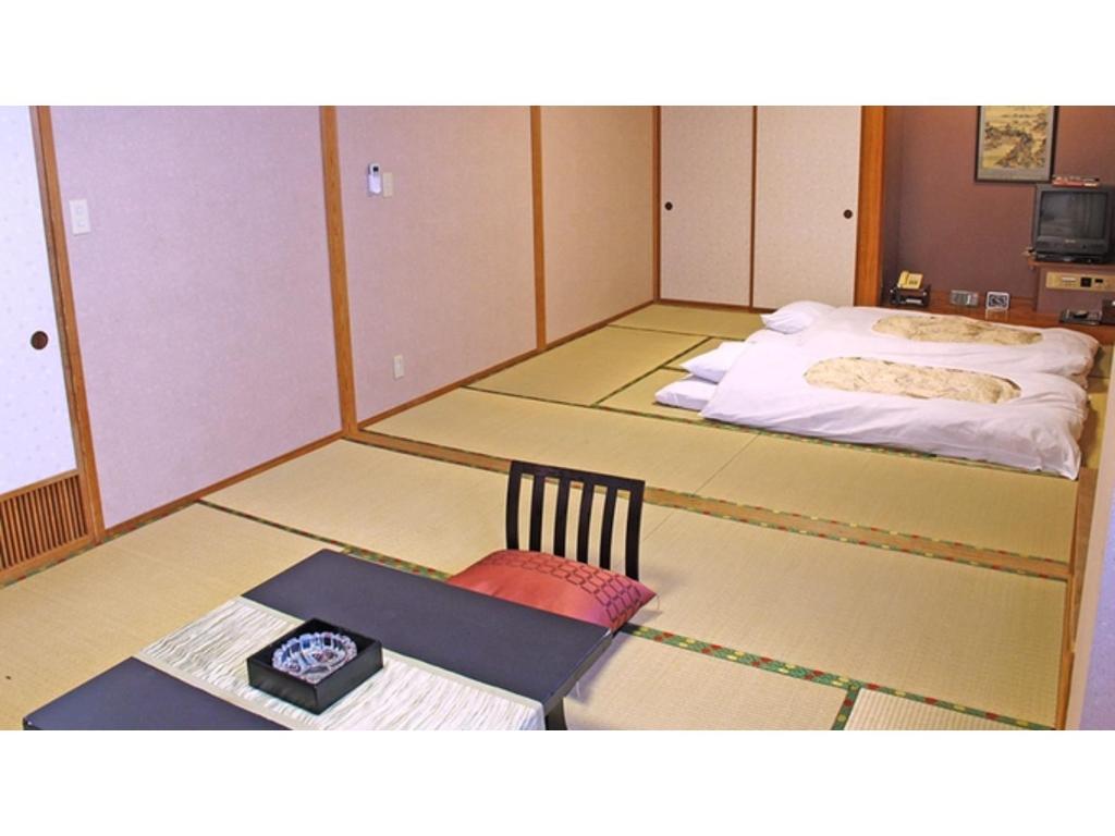 a room with a bed and a table and a chair at Hotel Platon - Vacation STAY 62258v in Chikuma