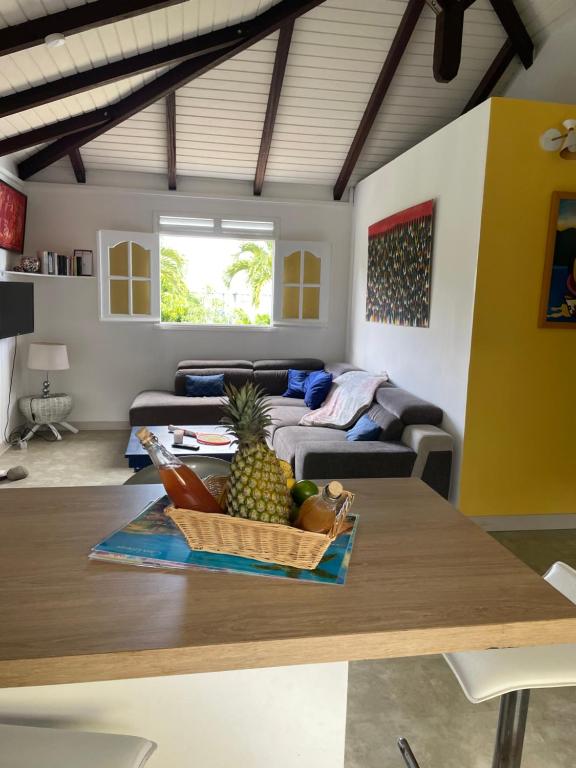 a living room with a table with a bowl of pineapple at Habitation Loumavi in Sainte-Rose