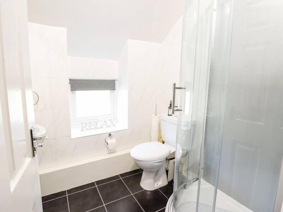 a white bathroom with a toilet and a shower at Harlech/HUGE Three bedroom/BEST location in Llanbedr