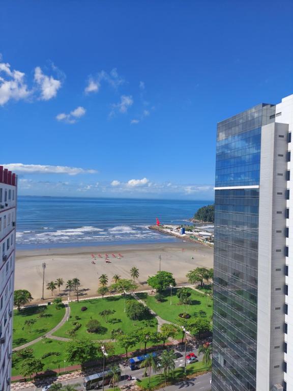 a view of the beach and the ocean from a building at Apartamento frente à praia in Santos