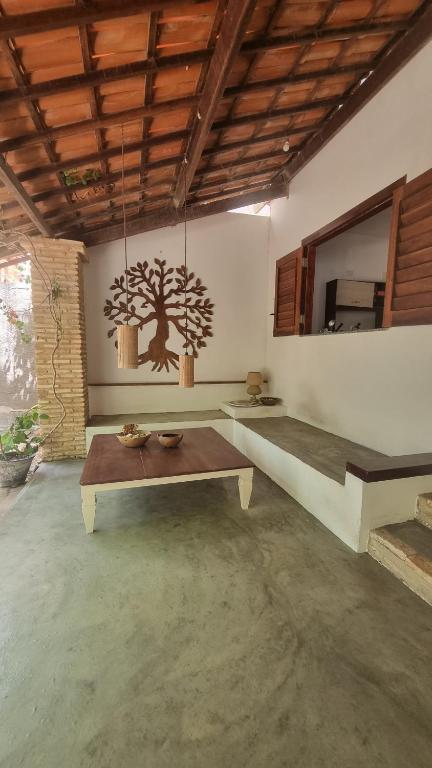una sala de estar con una mesa y un árbol en la pared en Casa Mangue, en Camocim