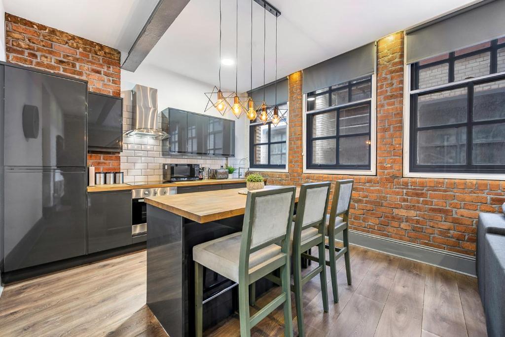 a kitchen with a brick wall and a table and chairs at Host & Stay - Bands Warehouse V in Liverpool