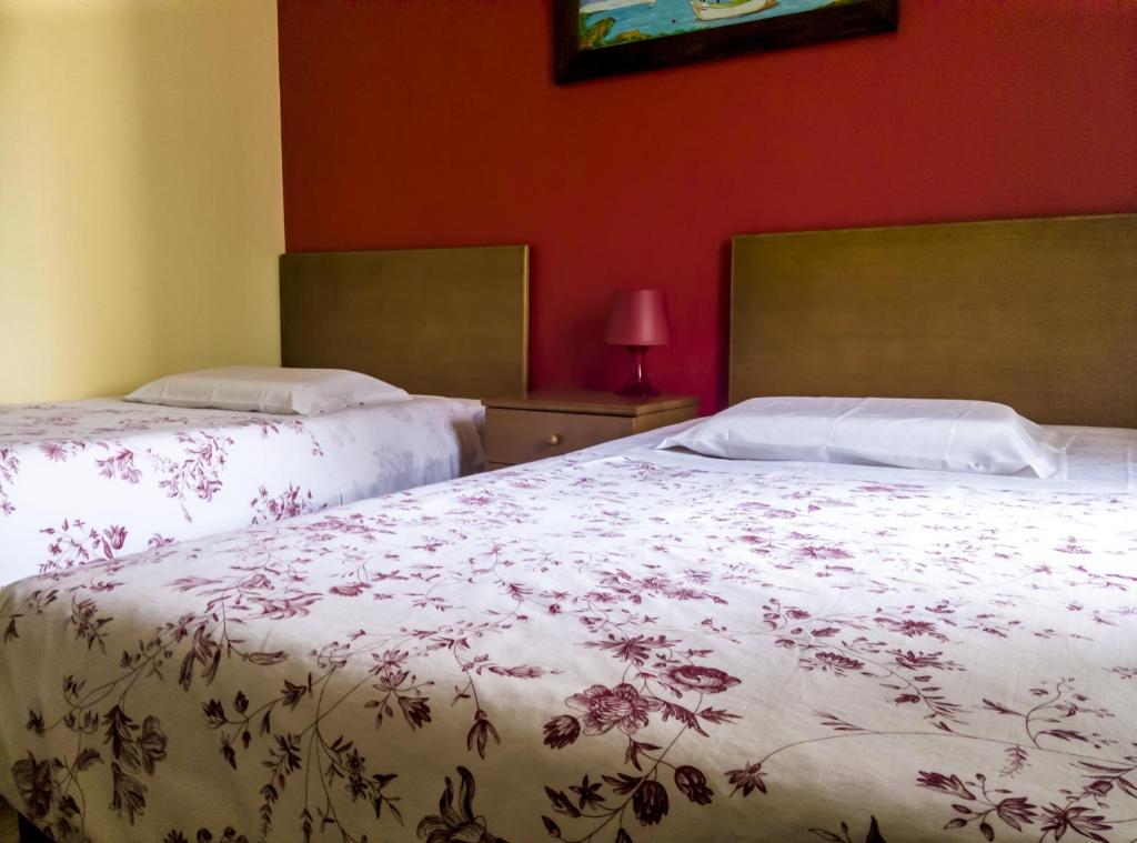 two beds sitting next to each other in a bedroom at Hotel O Catraio in Montijo