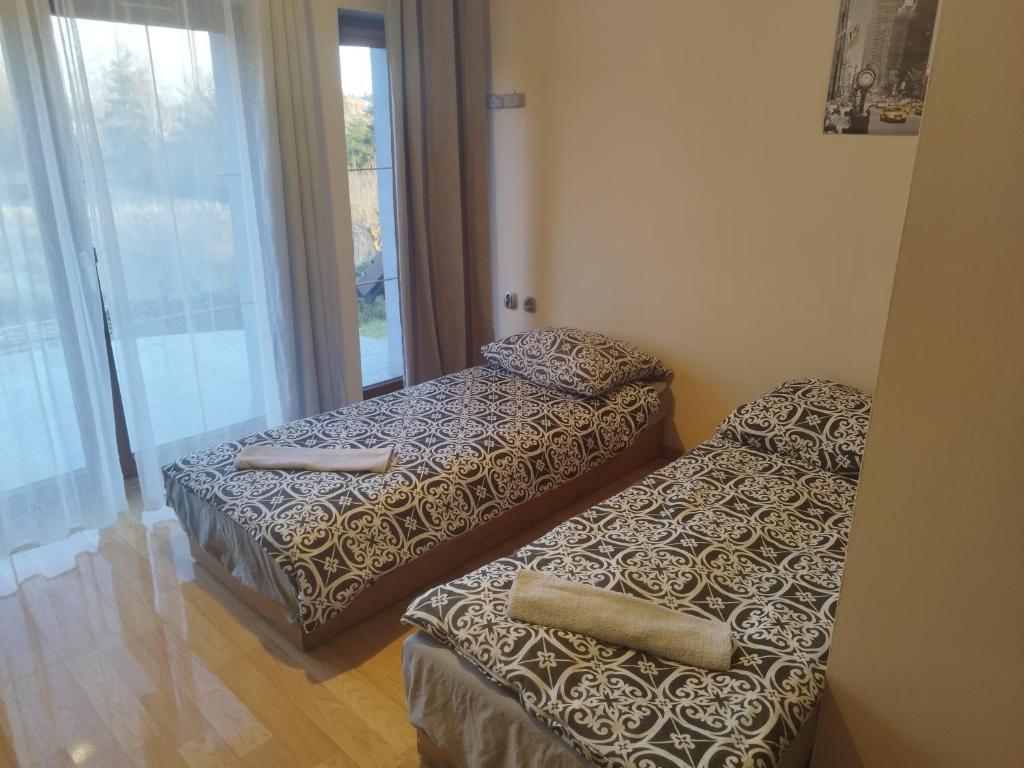 2 camas individuales en una habitación con ventana en Ceramika Bolesławiec - Pensjonat, en Bolesławiec