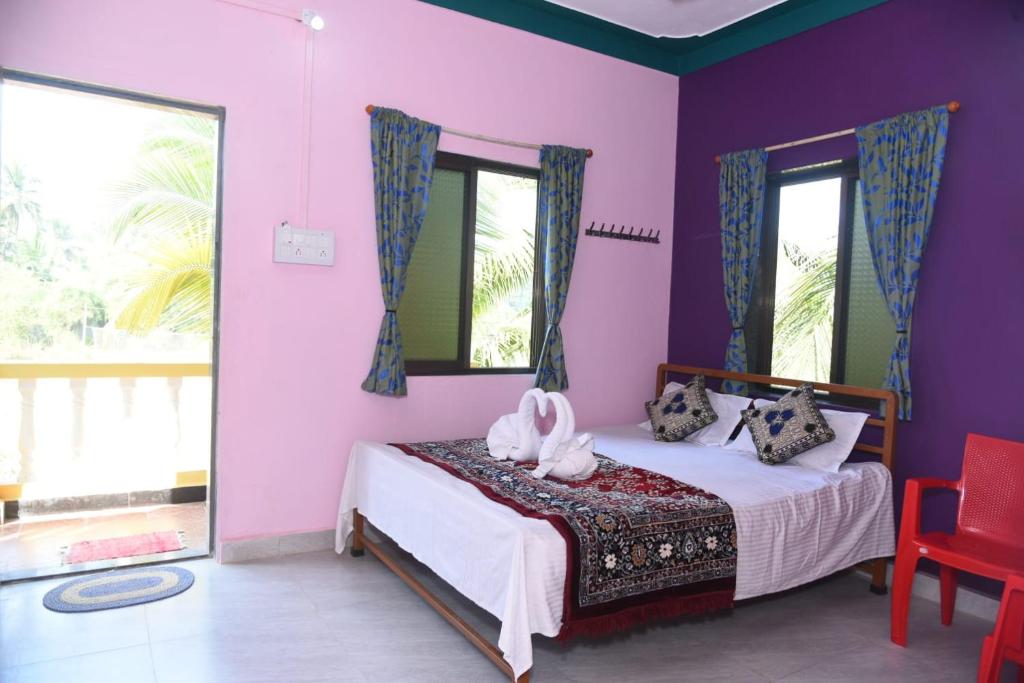a bedroom with a bed with purple walls and windows at NISARG HOME STAY near Bus Stand Malvan in Malvan