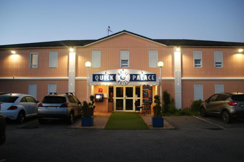 a front view of a hotel with cars parked in a parking lot at Quick Palace Epinal in Épinal